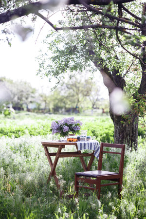 tea party in the garden. bouquet of lilacs, tea and glasses on the table. still life