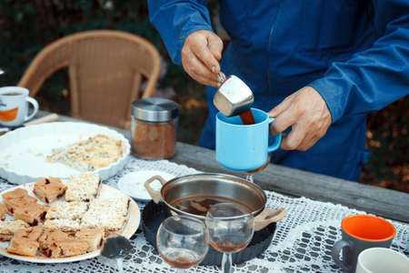 man pouring coffee into a cup. lunch in the gardenの写真素材