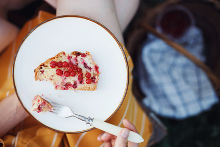 garden and still life. tea party in the garden - girl holding a plate with pieces of currant  pie.