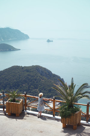 girl tourist stands on the observation deck and looking view of the Paleokastritsa bay, Corfu Island in Greecethe seaの写真素材