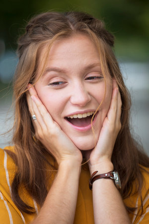 fun portrait of beautiful smiling girl at the parkの写真素材