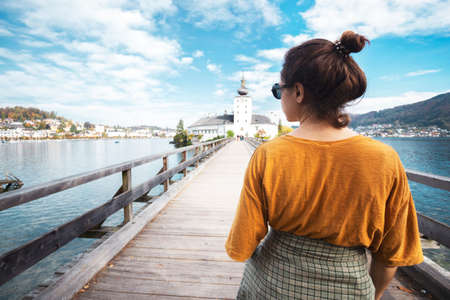 happy girl goes over the bridge to the castle ort, austriaの写真素材