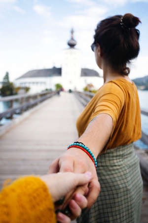 happy girl goes over the bridge to the castle ort, austriaの写真素材