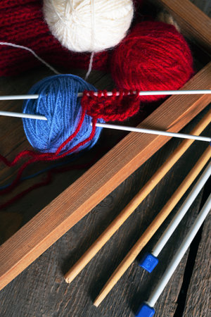 hobby. knitting - set of multicolored balls threads and knitting needles on a wooden table
