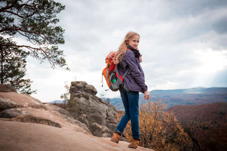 girl with a backpack stands on Dovbush rocks at the Carpathians, Ukraineの写真素材