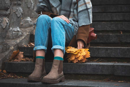 autumn in the city. girl holding a yellow leaf in her hand. accessories and partsの写真素材