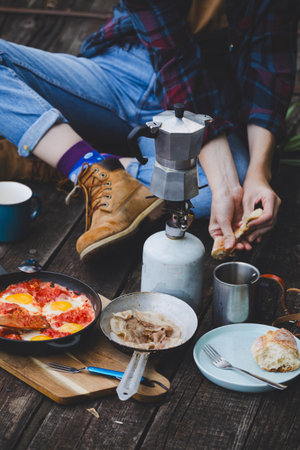 girl preparing breakfast on the pier. camping aesthetics  in the wildの写真素材