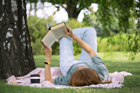 girl reading a book on the lawn