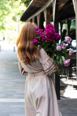 Ukrainian girl in vyshyvanka with a bouquet of peoniesの写真素材