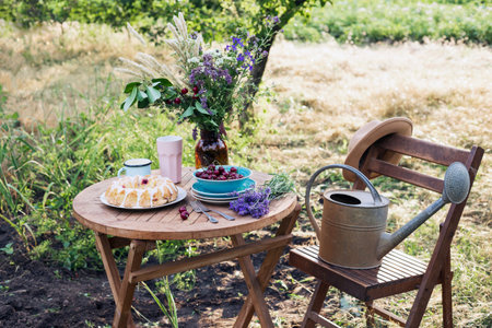 garden and tea party at the country style. still life - Ñherry pie, cups, dishes and a vase with...