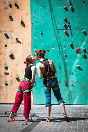 a guy and a girl climbers kiss against the background of a bouldering wallの写真素材