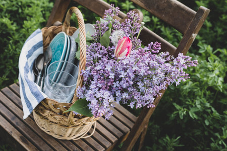 picnic basket with dishes and a bouquet of flowers