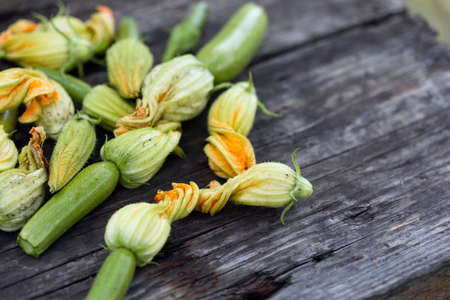 zucchini with flowers on a wooden backgroundの写真素材