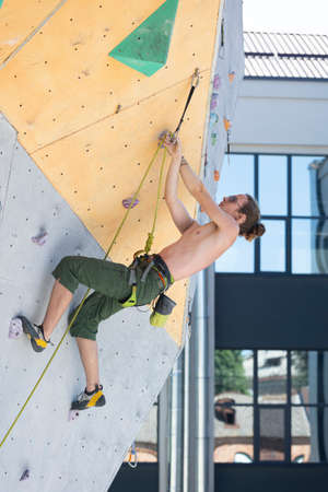 bouldering, man climbing up the wallの写真素材