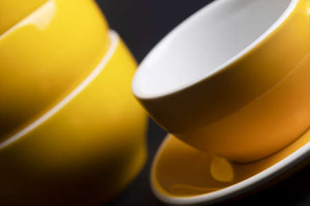 bright ceramics - bowl and cups in yellow colors on a black backgroundの写真素材