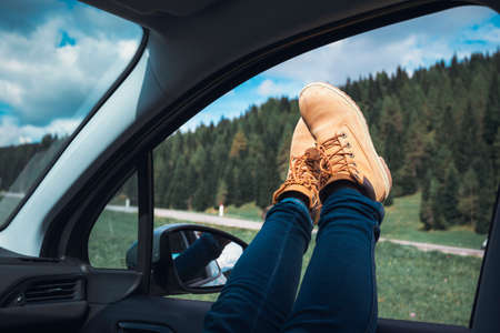 Girl legs in bright boots sticking out of the car. Dolomites, Italy.の写真素材