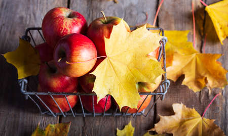 apples in a basket on a wooden tableの写真素材