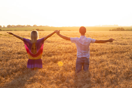 woman and man in the field in the sunset lightの写真素材