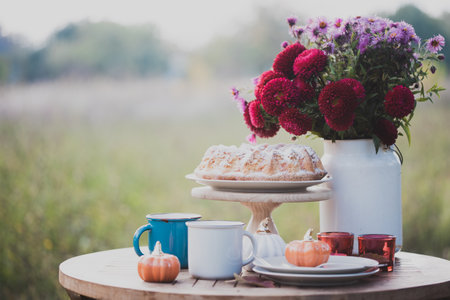 autumn mood. tea in the garden. apple pie, tea, aster bouquet and pumpkin decorの写真素材