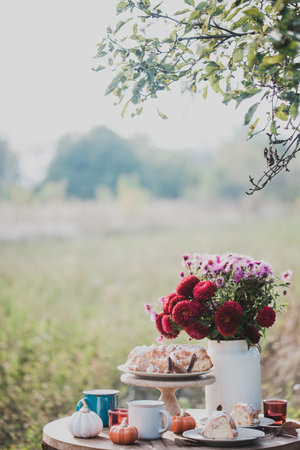 autumn mood. tea in the garden. apple pie, tea, aster bouquet and pumpkin decorの写真素材