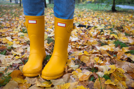 bright autumn. girl in yellow rubber boots walkingの写真素材