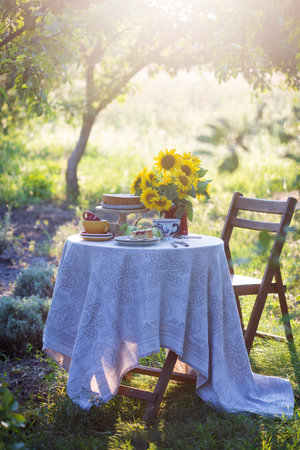 garden and still life. tea party in the garden - pie, vase with sunflowers and apples on a tableの写真素材