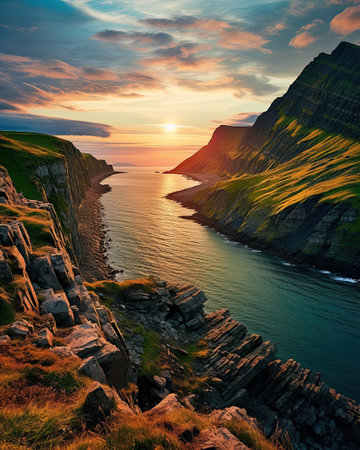 Tranquil ocean reflecting sunset, cliffs, mountains, and serene beach. Ideal travel destination.の素材