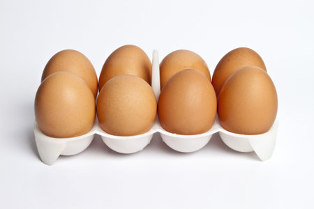 8 eggs in a box on a light background