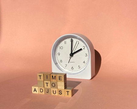 Time to adjust - adjusting or changing the time on white clock. Time management concept.の写真素材