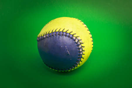 softball ball isolated on green backgroundの写真素材
