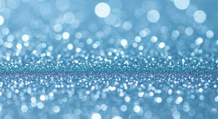 This image showcases a close-up view of a shimmering blue glitter background. The glitter particles are densely packed at the bottom, gradually dispersing into a soft, glowing bokeh effect towards the top. The overall effect is ethereal and captivating, creating a sense of depth and sparkle.の素材