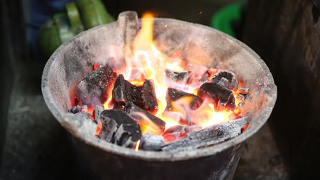 Burning charcoal in a cauldron for making food in a restaurantの写真素材
