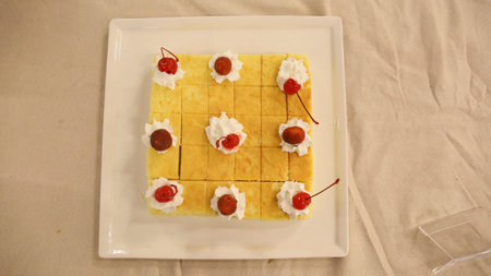 waffles with cherries and whipped cream on a white plate top view