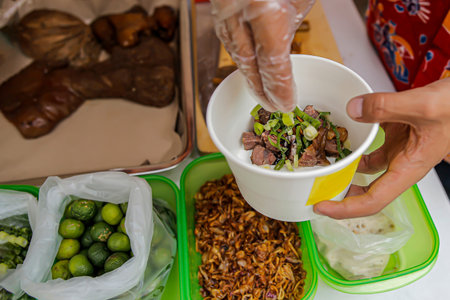 Put spring onions in a paper bowl to make delicious Soto Betawi