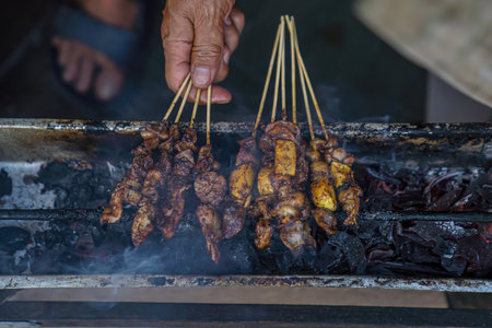 A close look at the process of grilling Madura satay while behind the satayの写真素材