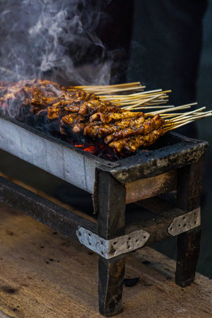 On a smoky grill is Madura satay