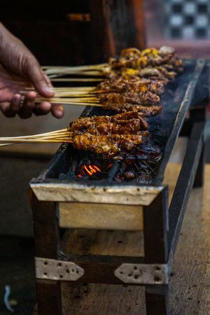 This is the process of making Madurese satay by grilling it over a hot coal fireの写真素材