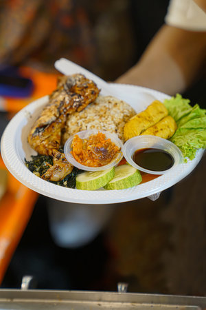Close up of grilled chicken rice and side dishes on a plate ready to be servedの写真素材