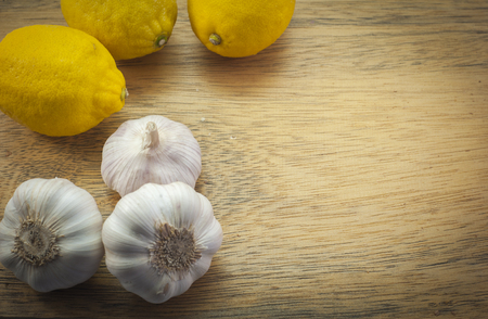 Three Lemons and white garlics on woodの写真素材