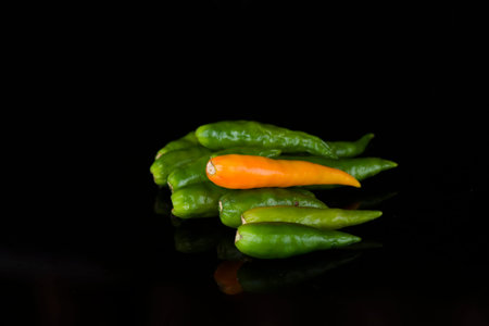Cayanne peppers isolated on black background
