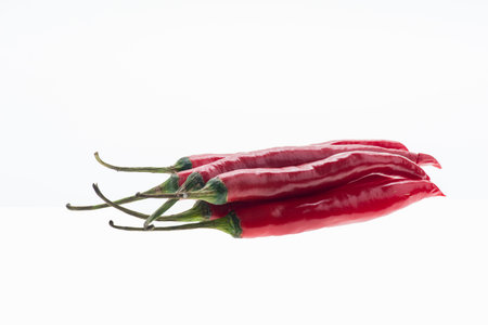 Red chili peppers isolated on white background. Reflection on glass