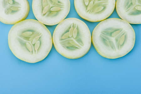 Close up fresh slice cucumber on blue backgroundの写真素材