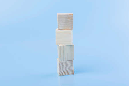 Blank natural wooden cube block vertical on blue backgroundの写真素材