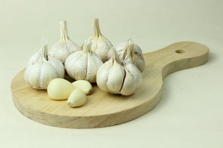 Garlic on wooden cutting board isolated on white background. close up.の写真素材