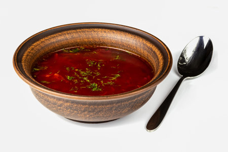 Traditional Ukrainian red borscht soup in ceramic plate with spoon isolated on white background.の写真素材