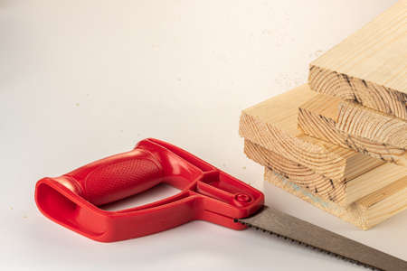 Pile of wood boards with a saw for DIY home project on white backgroundの写真素材