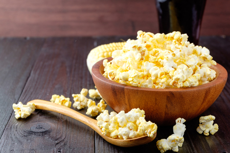 Popcorn in a bowl on wooden background.の写真素材