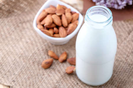 Almond milk in glass bottle on wood backgroundの写真素材
