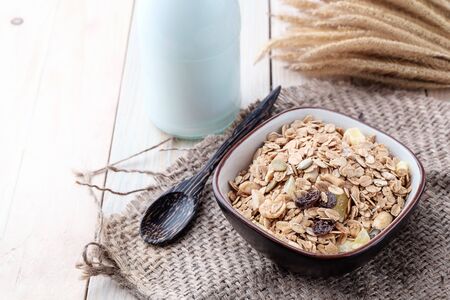 Breakfast cereals with dried fruits in a bowl on a wooden background.の写真素材