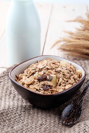 Breakfast cereals with dried fruits in a bowl on a wooden background.の写真素材